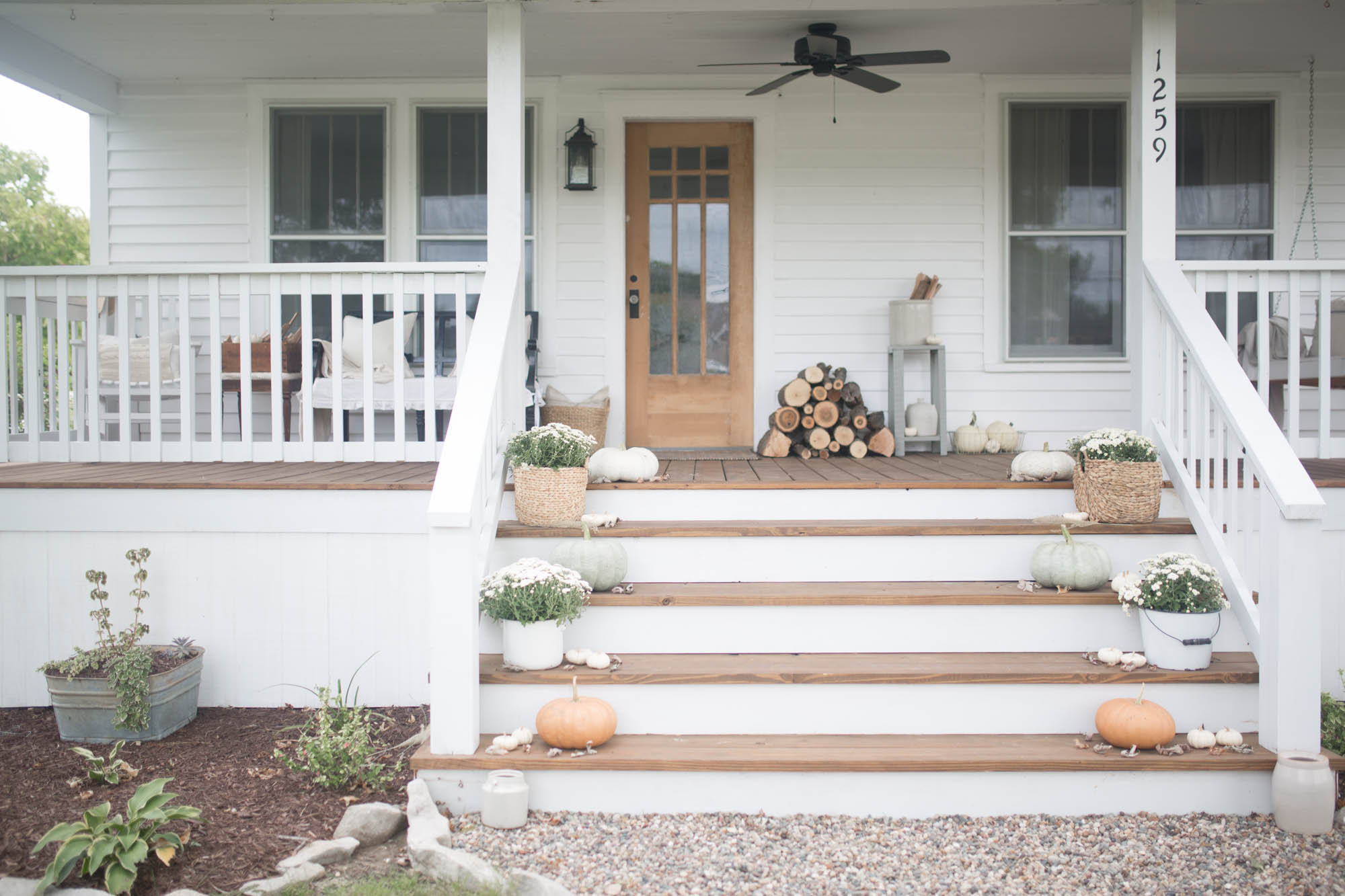 Farmhouse front porch with decorations on steps